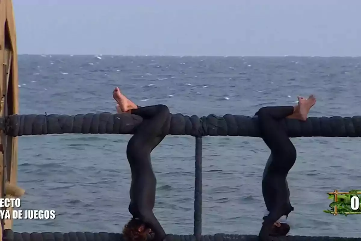 Personas colgando boca abajo de una estructura sobre el mar. Personas colgando boca abajo de una estructura sobre el mar.