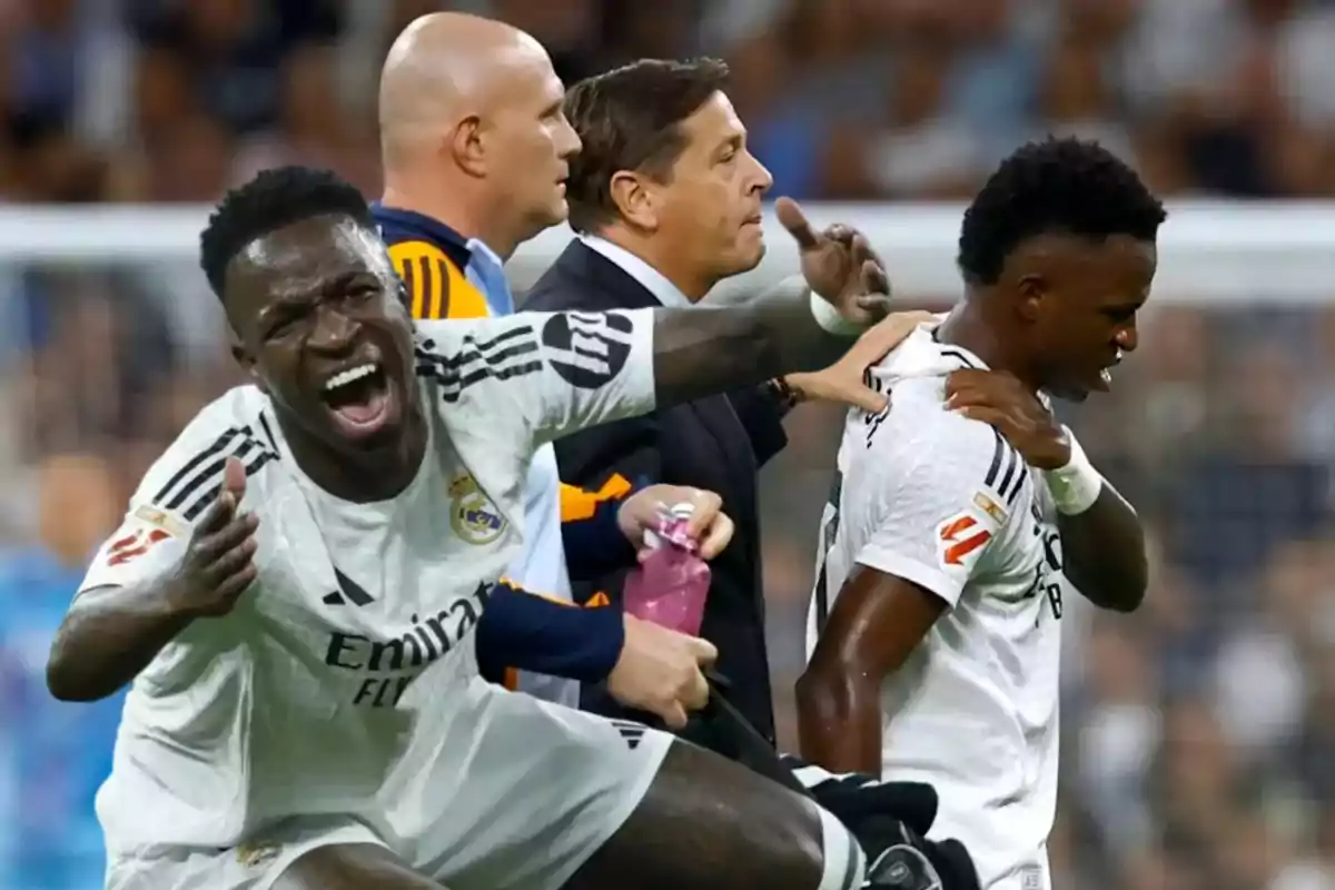 Jugadores de fútbol del Real Madrid en el campo, uno de ellos grita mientras otro parece estar lesionado y es asistido por el personal técnico.