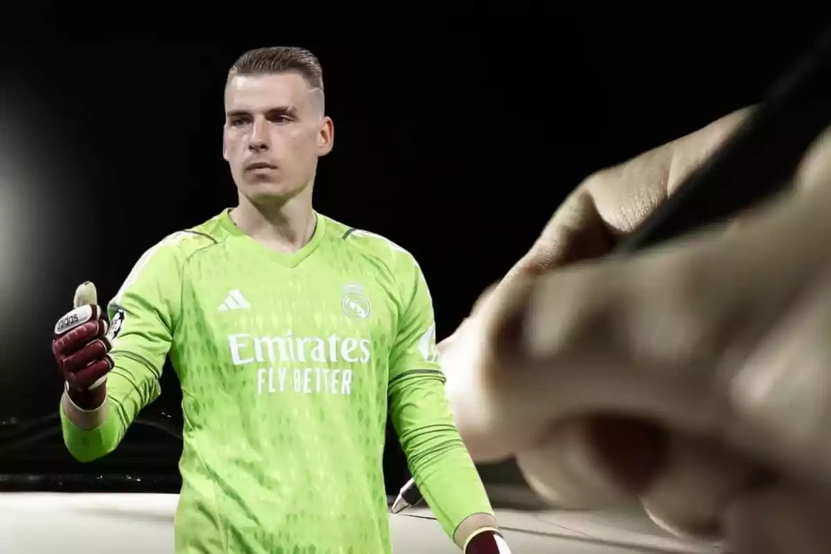 Un portero de fútbol con uniforme verde del Real Madrid, con guantes rojos y blancos, en un campo de juego, con una mano escribiendo en el fondo.