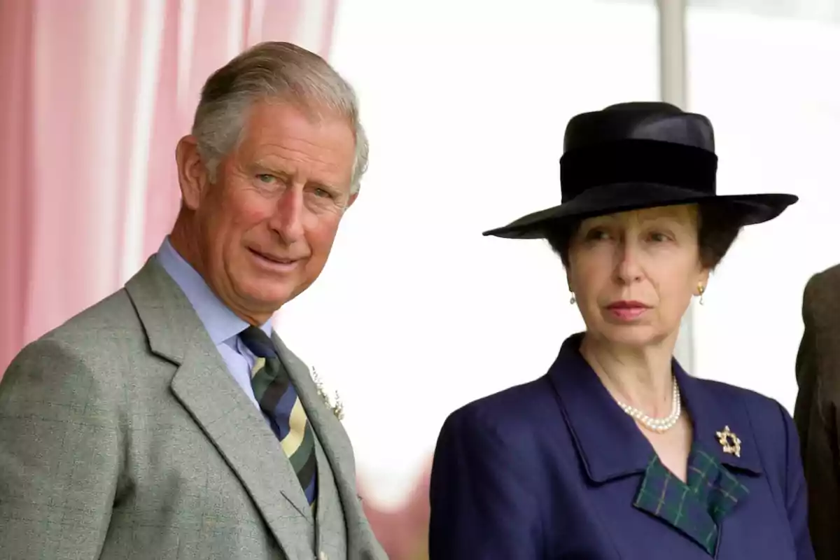 Dos personas vestidas formalmente, un hombre con traje gris y una mujer con sombrero negro y collar de perlas. Dos personas vestidas formalmente, un hombre con traje gris y una mujer con sombrero negro y collar de perlas.
