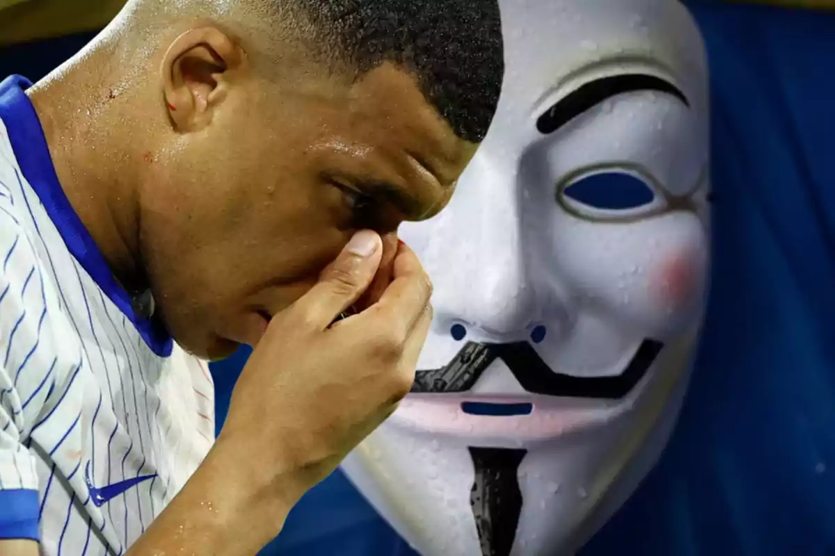 Kylian Mbappé con la camiseta de Francia se agarra la nariz y de fondo una máscara de la película 'V de Vendetta'