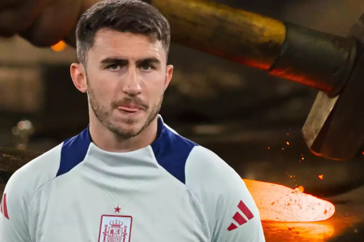 Un hombre con una camiseta de entrenamiento de la selección española de fútbol está en primer plano, mientras que en el fondo se ve una escena de forja con un martillo golpeando metal caliente.