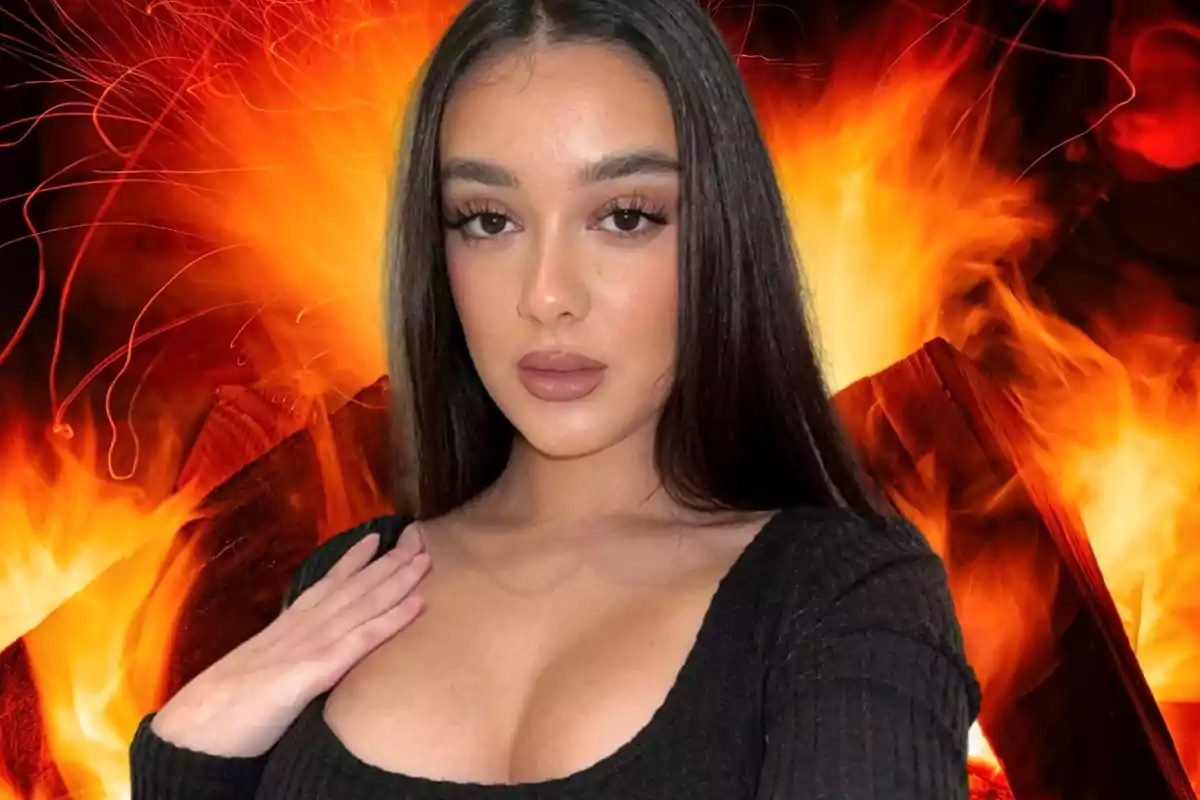 Julia Janeiro posa con un vestido negro y de fondo una enorme imagen de un fuego