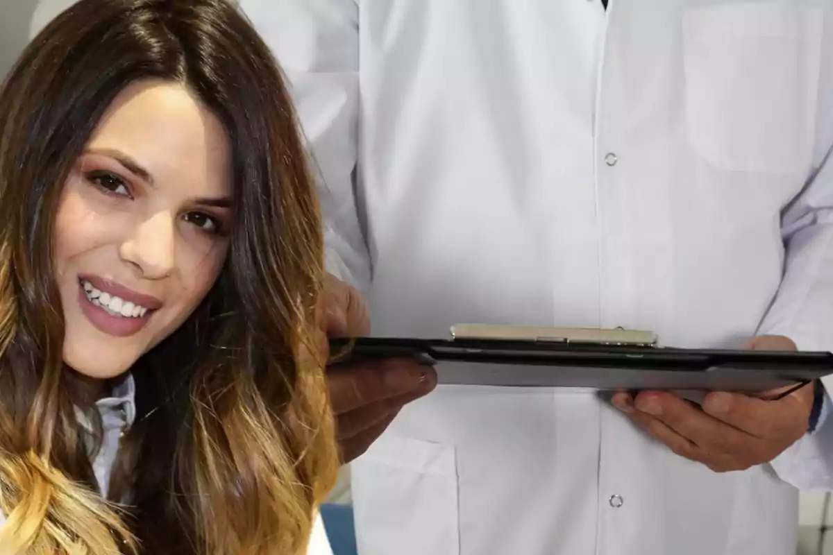 Una mujer sonriente junto a una persona con bata blanca sosteniendo una carpeta.