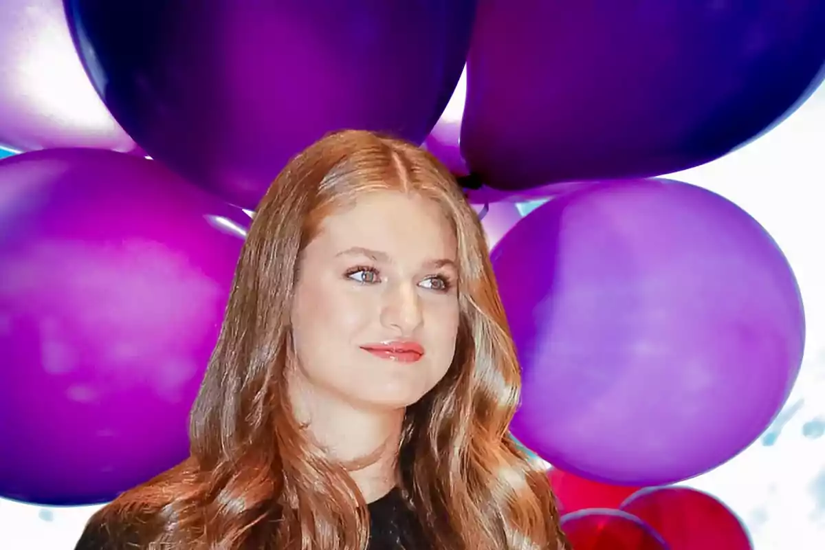 Una persona con cabello rubio y suelto está frente a un fondo de globos morados.