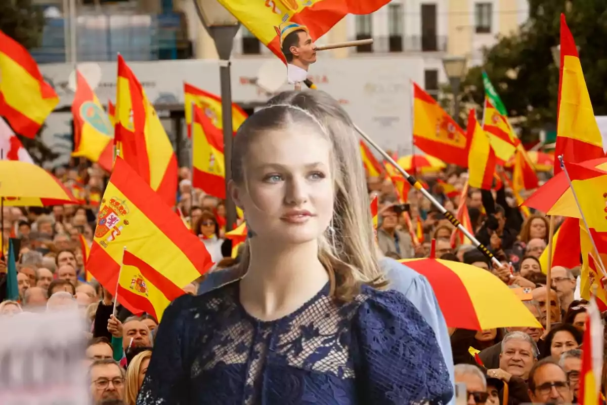 Una multitud de personas con banderas de España y una mujer en primer plano.