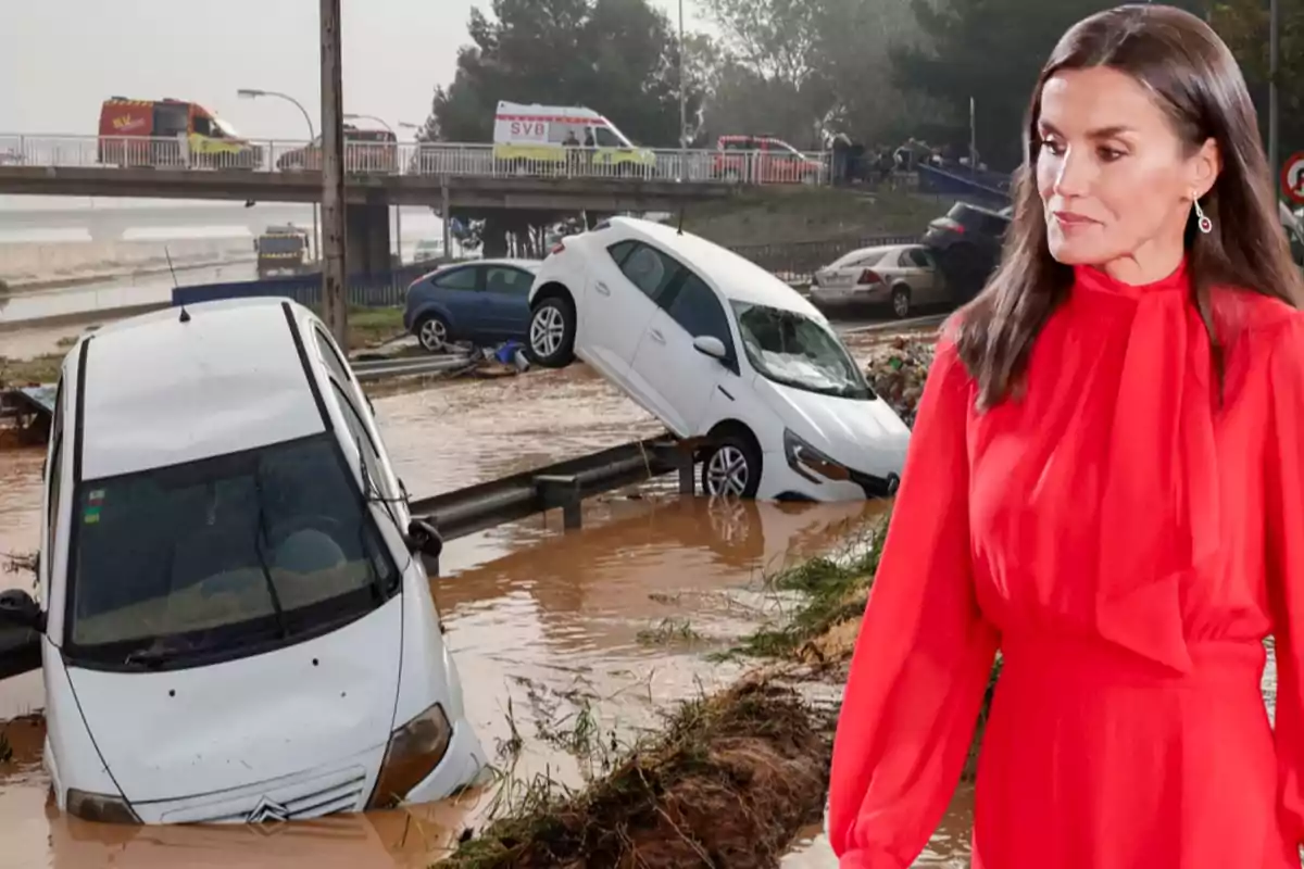 Una mujer con vestido rojo está en primer plano mientras al fondo se ven coches atrapados en una inundación y vehículos de emergencia en un puente.