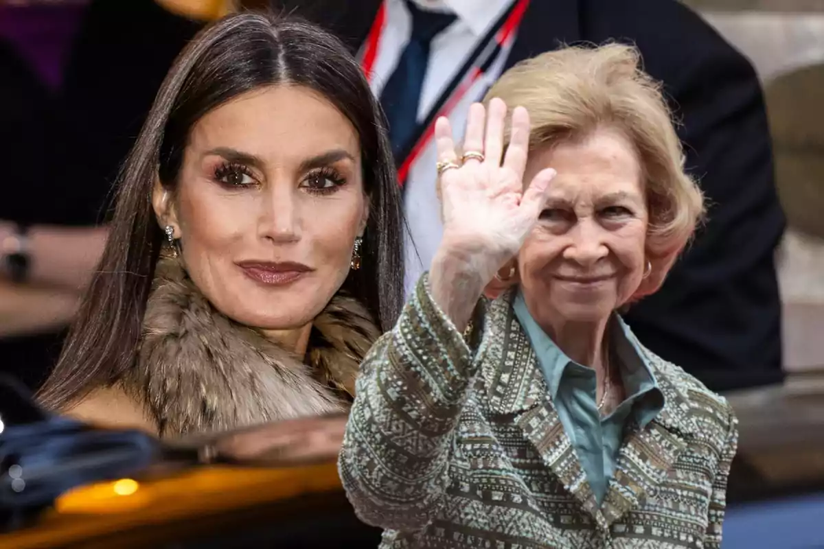 Dos mujeres sonrientes, una con cabello oscuro y abrigo de piel, la otra con cabello claro y chaqueta estampada, saludando en un evento público.