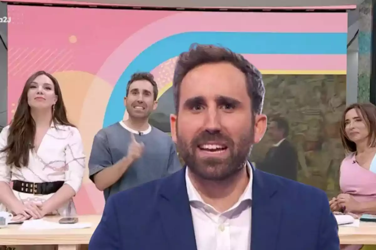 Cuatro personas en un set de televisión con fondo colorido y una imagen de un hombre en primer plano al centro