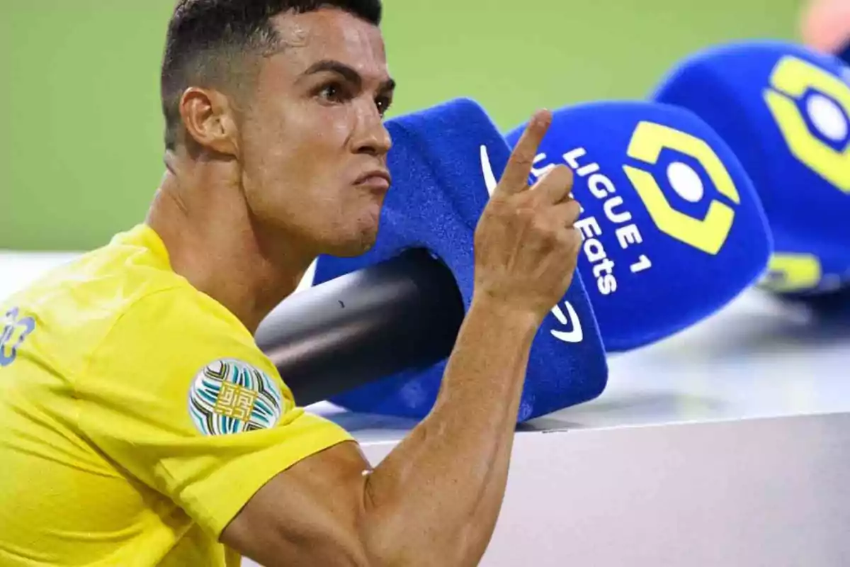 Un jugador de fútbol con camiseta amarilla gesticula frente a un micrófono azul de la Ligue 1.