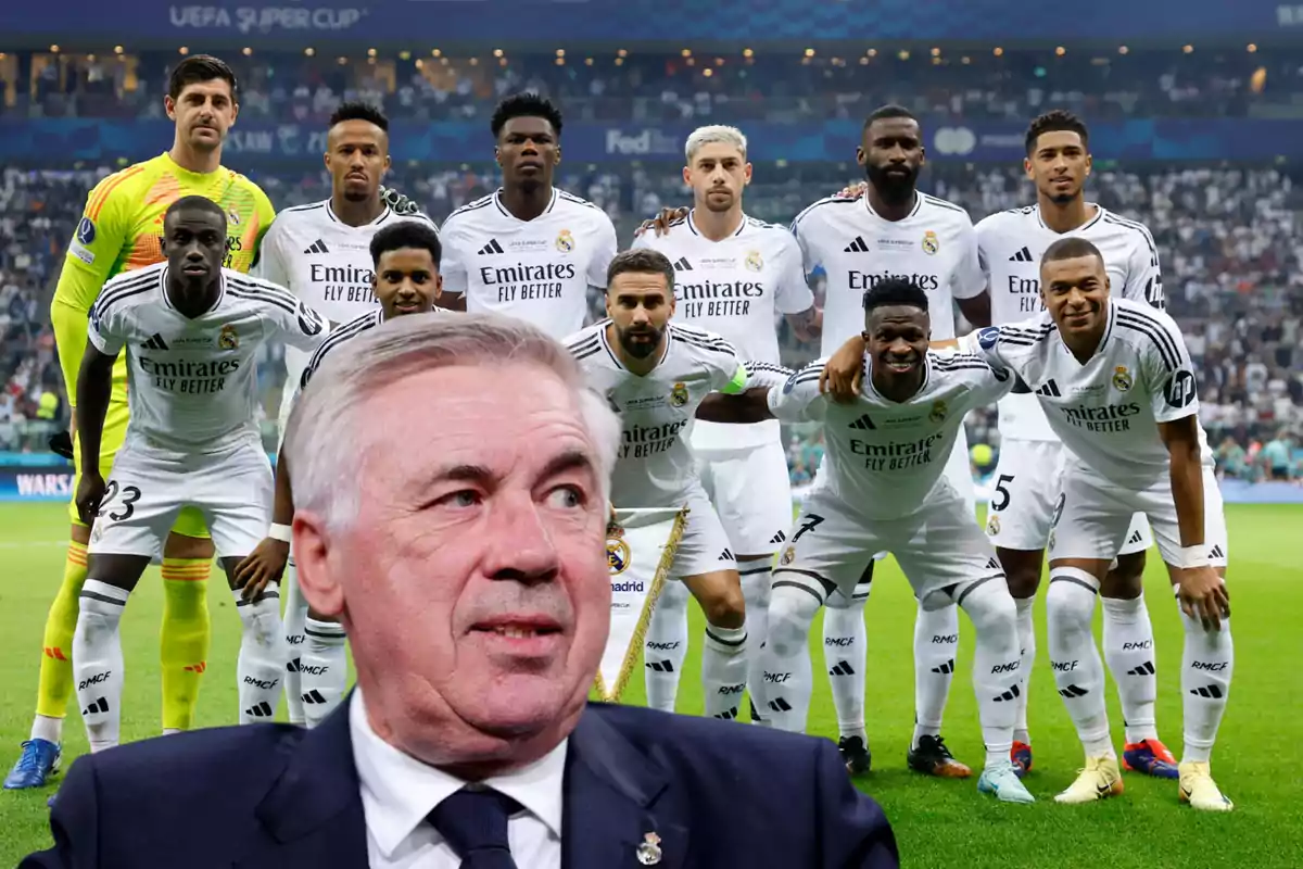 Un equipo de fútbol posando para una foto grupal en el campo con su entrenador en primer plano.