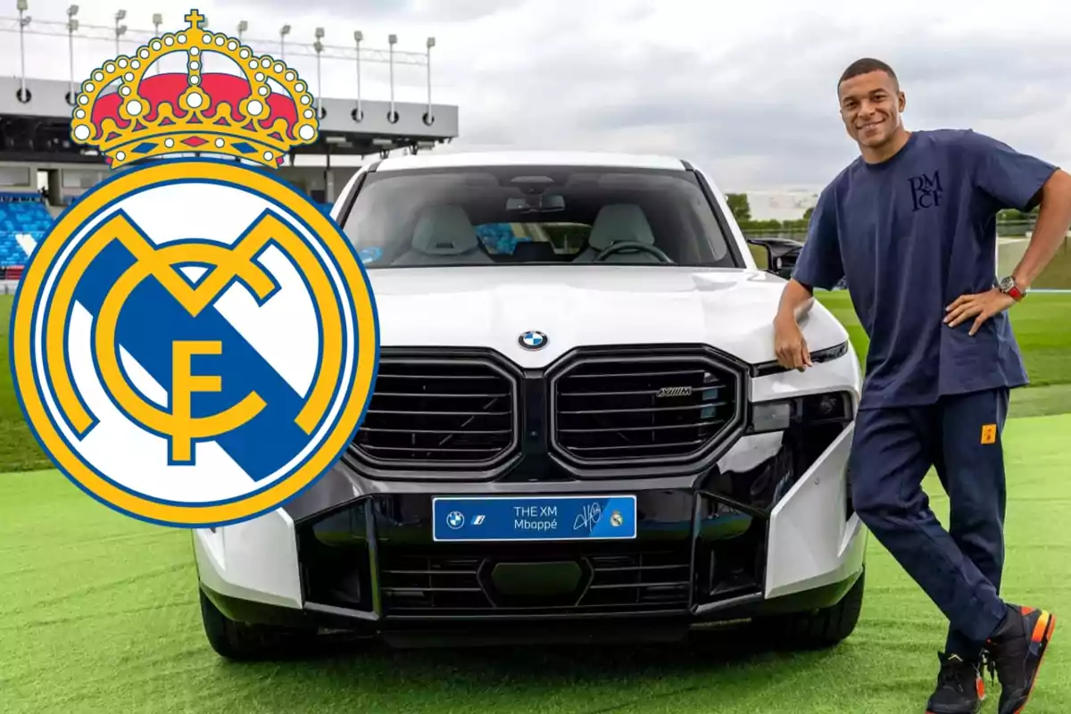 Un hombre con una camiseta azul oscuro está apoyado en un coche BMW blanco en un campo de fútbol con el logo del Real Madrid superpuesto en la imagen.