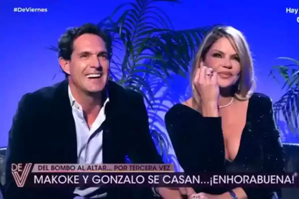 Una pareja sonriente en un programa de televisión con un fondo azul y plantas. Una pareja sonriente en un programa de televisión con un fondo azul y plantas.