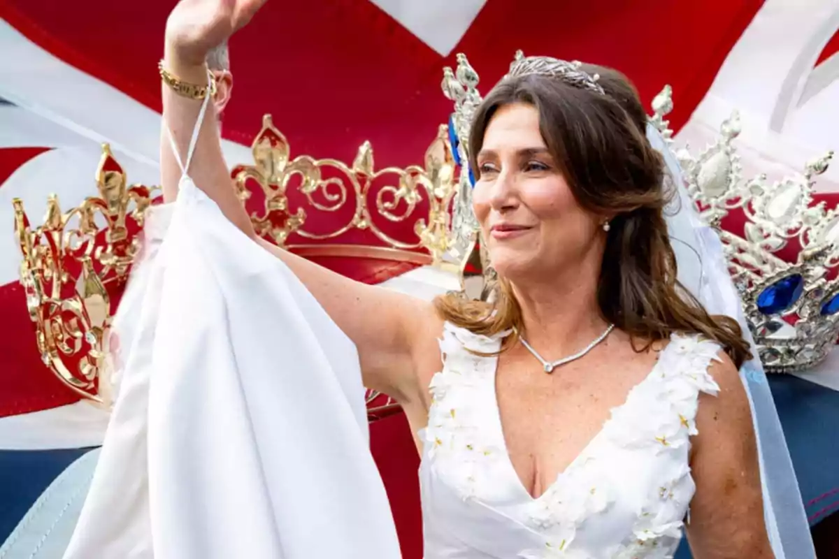 Una mujer con vestido blanco y tiara, levantando la mano, con coronas doradas y plateadas en el fondo.