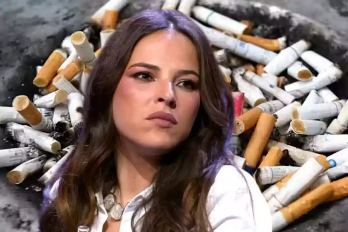 Mujer de cabello largo y expresión seria frente a un fondo lleno de colillas de cigarro