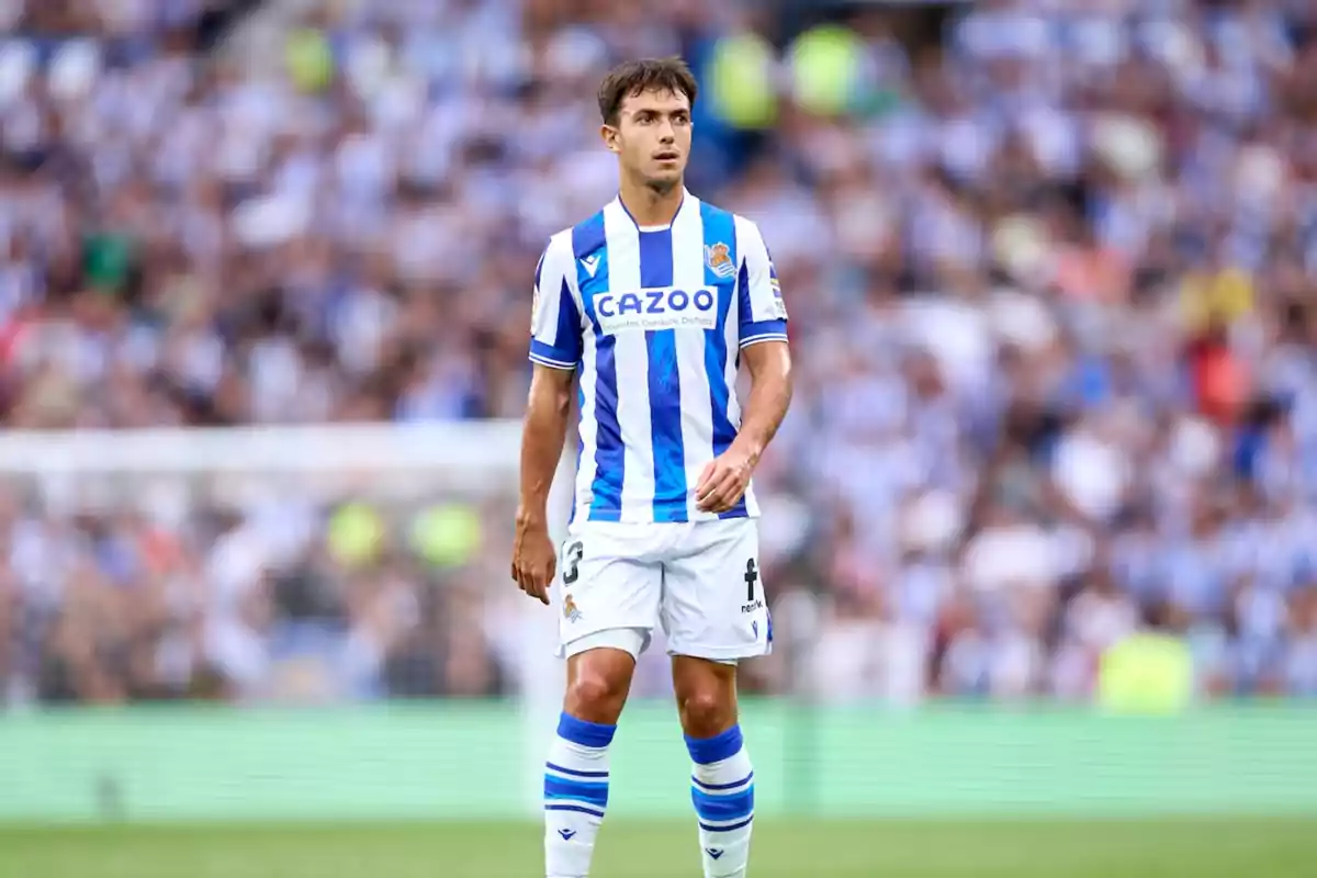 Jugador de fútbol con uniforme de la Real Sociedad en el campo de juego.