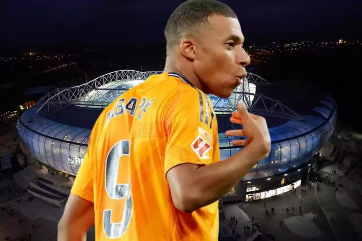 Un jugador de fútbol con la camiseta número 9 en color naranja está celebrando frente a un estadio iluminado por la noche.