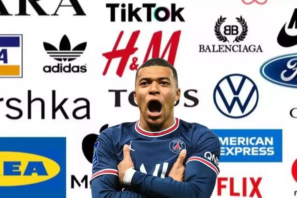 Un jugador de fútbol con la boca abierta y los brazos cruzados, vistiendo el uniforme del Paris Saint-Germain, con varios logotipos de marcas conocidas en el fondo.