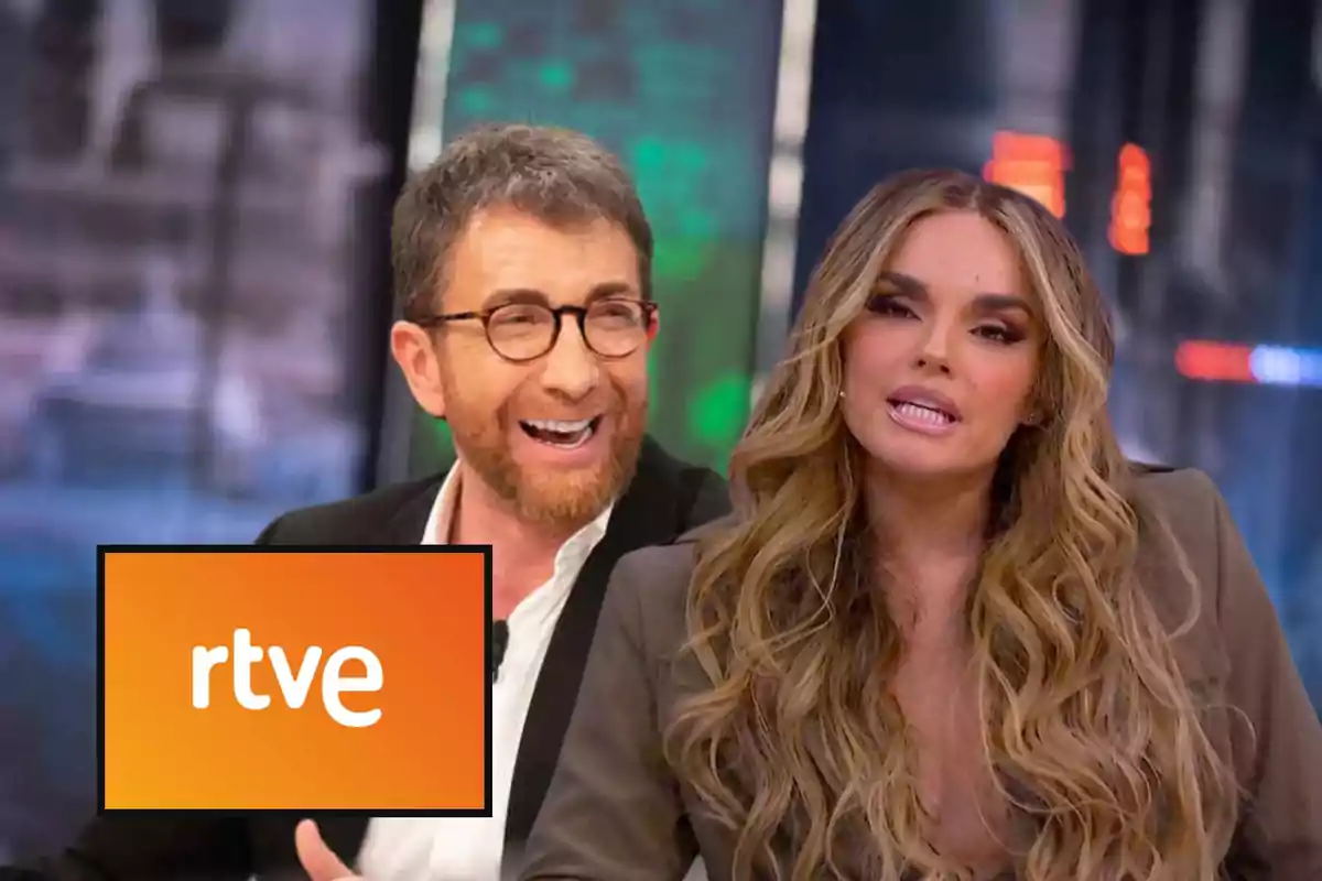 Dos presentadores de televisión conversando en un plató con el logo de rtve en primer plano