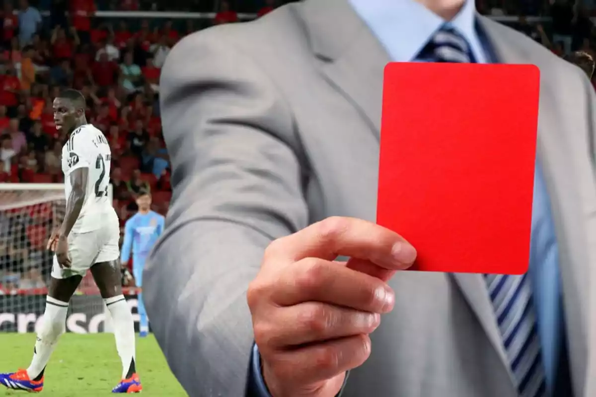 Un árbitro muestra una tarjeta roja a un jugador de fútbol en el campo.