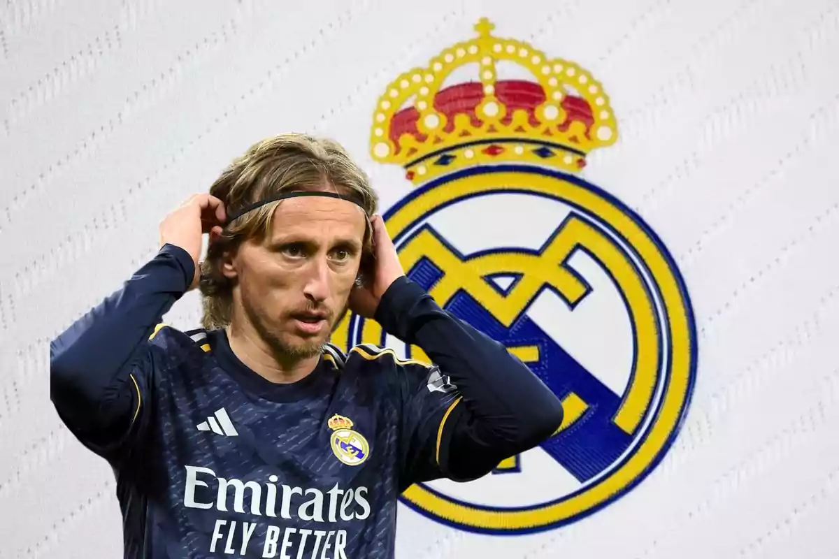 Luka Modric con el escudo del Real Madrid detrás