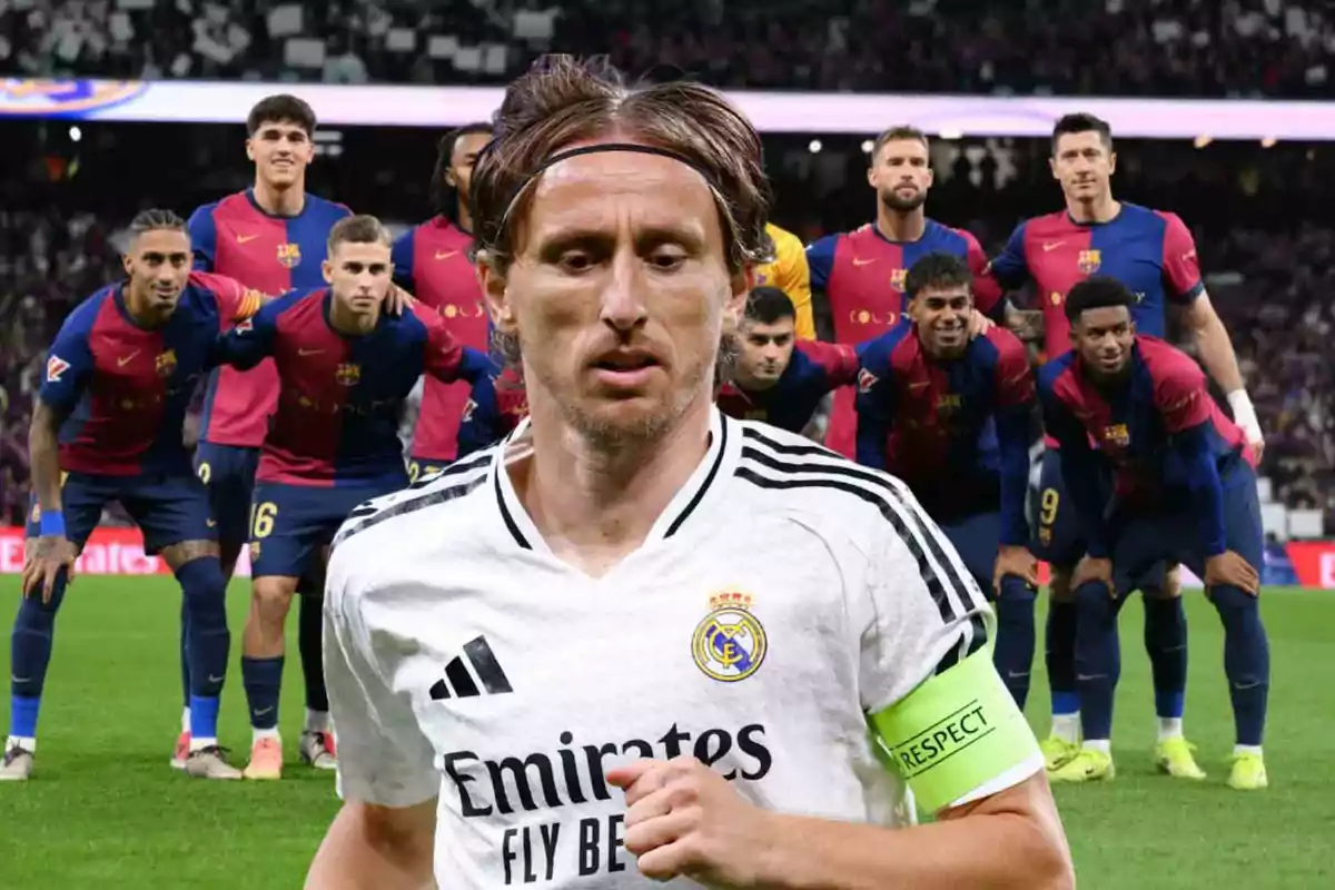 Un jugador del Real Madrid en primer plano con jugadores del Barcelona al fondo en un estadio de fútbol.