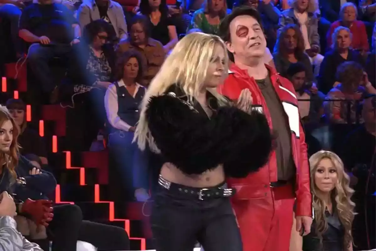 Un grupo de personas está en un estudio de televisión, algunas de ellas están vestidas con atuendos llamativos, mientras el público observa desde las gradas. Un grupo de personas está en un estudio de televisión, algunas de ellas están vestidas con atuendos llamativos, mientras el público observa desde las gradas.