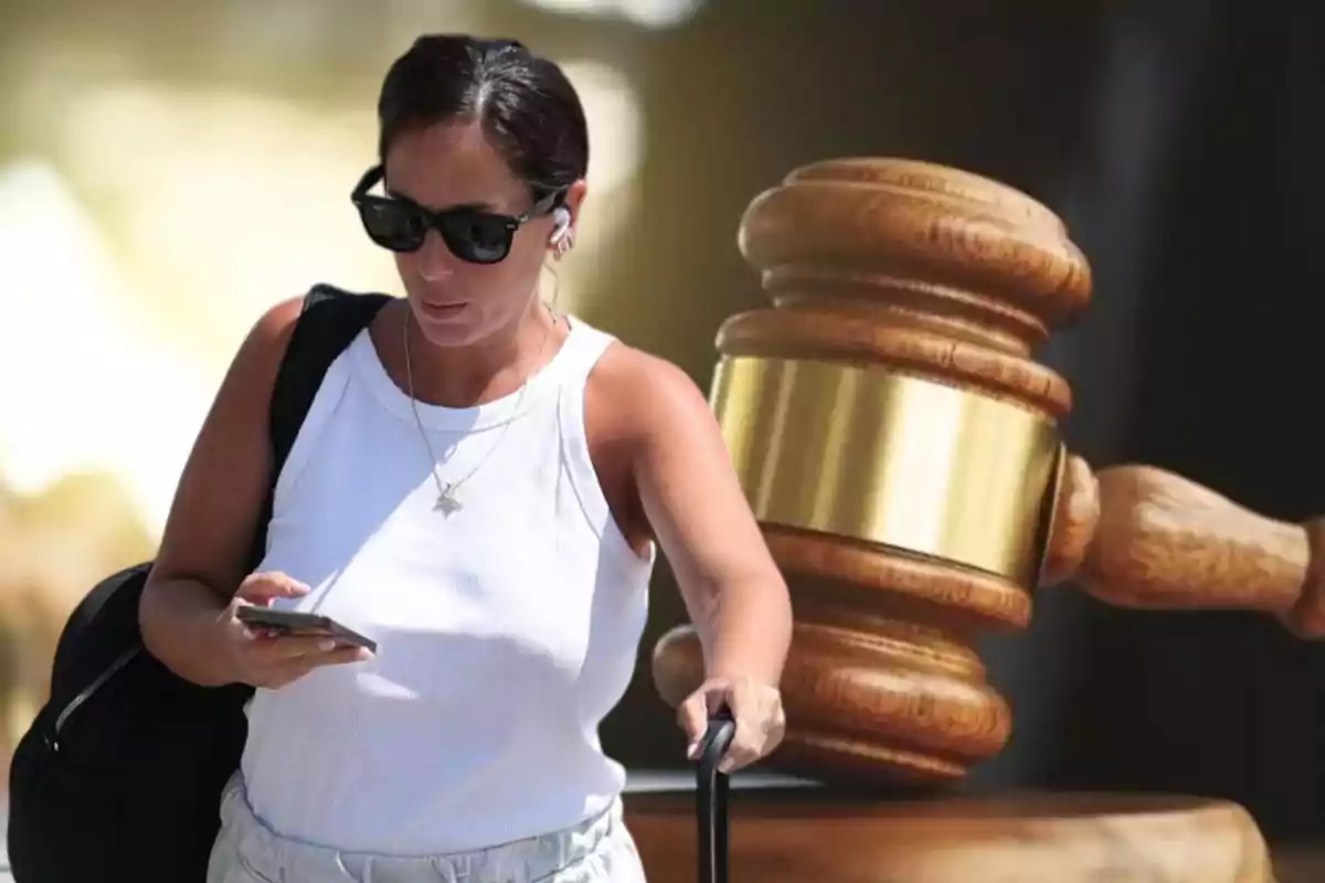 Una mujer con gafas de sol y auriculares revisa su teléfono mientras lleva una maleta, con un mazo de juez en el fondo.