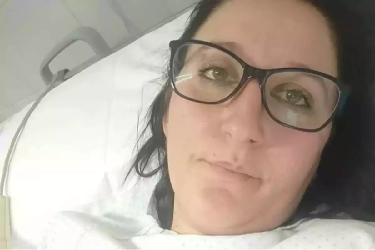 Una persona con gafas está recostada en una cama de hospital. Una persona con gafas está recostada en una cama de hospital.