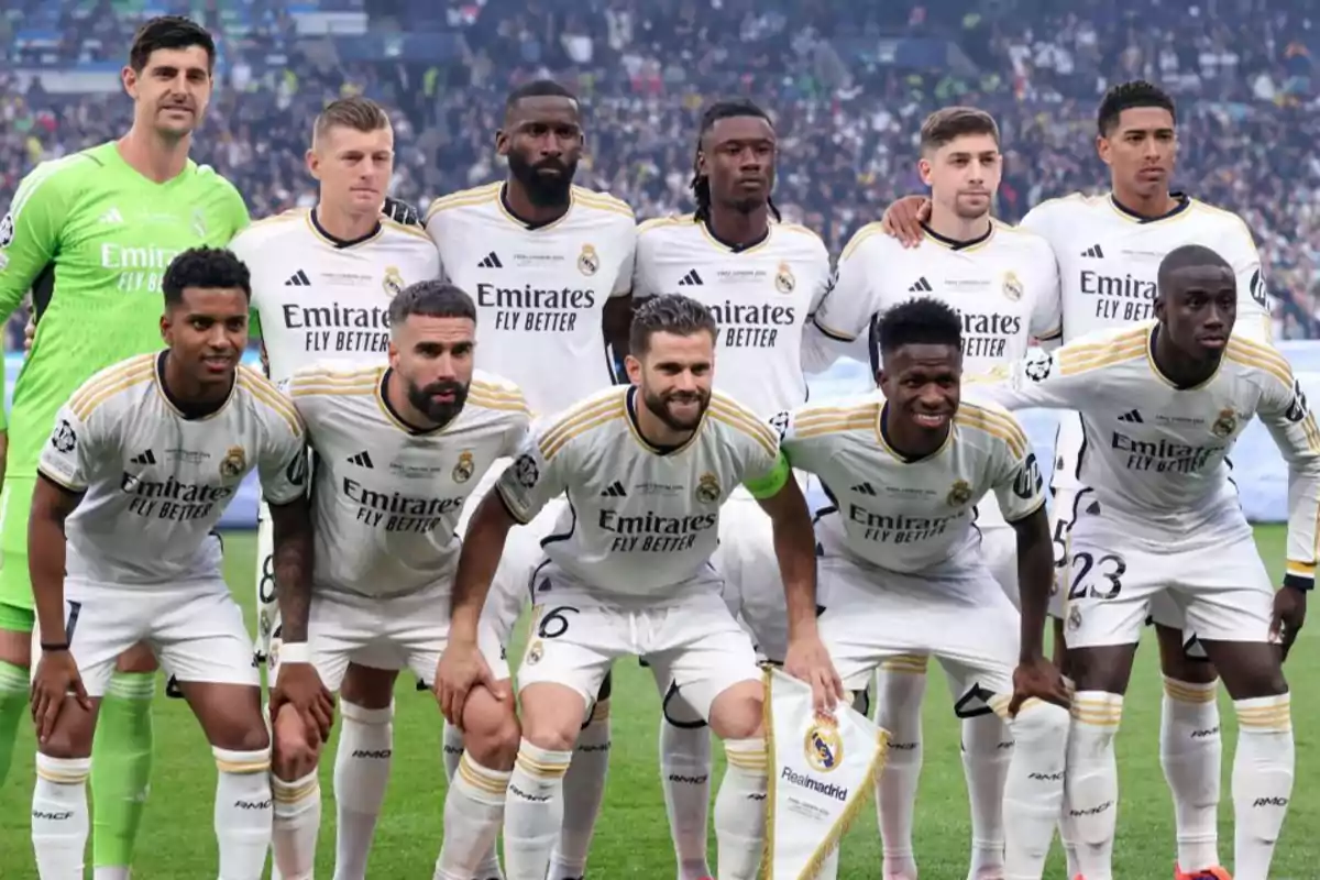 Jugadores del Real Madrid posando para una foto de equipo antes de un partido, todos vistiendo el uniforme blanco del club.