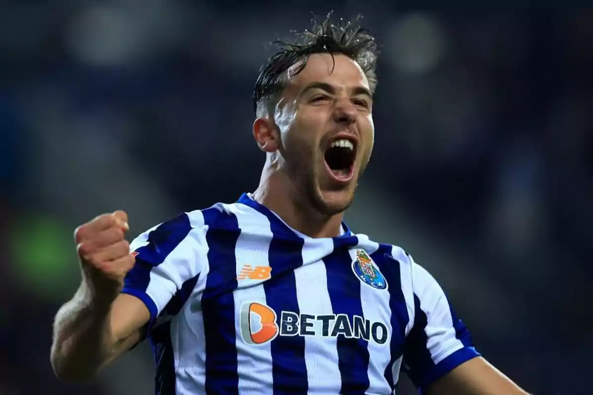 Un jugador de fútbol celebrando con entusiasmo mientras lleva una camiseta a rayas azules y blancas. Un jugador de fútbol celebrando con entusiasmo mientras lleva una camiseta a rayas azules y blancas.
