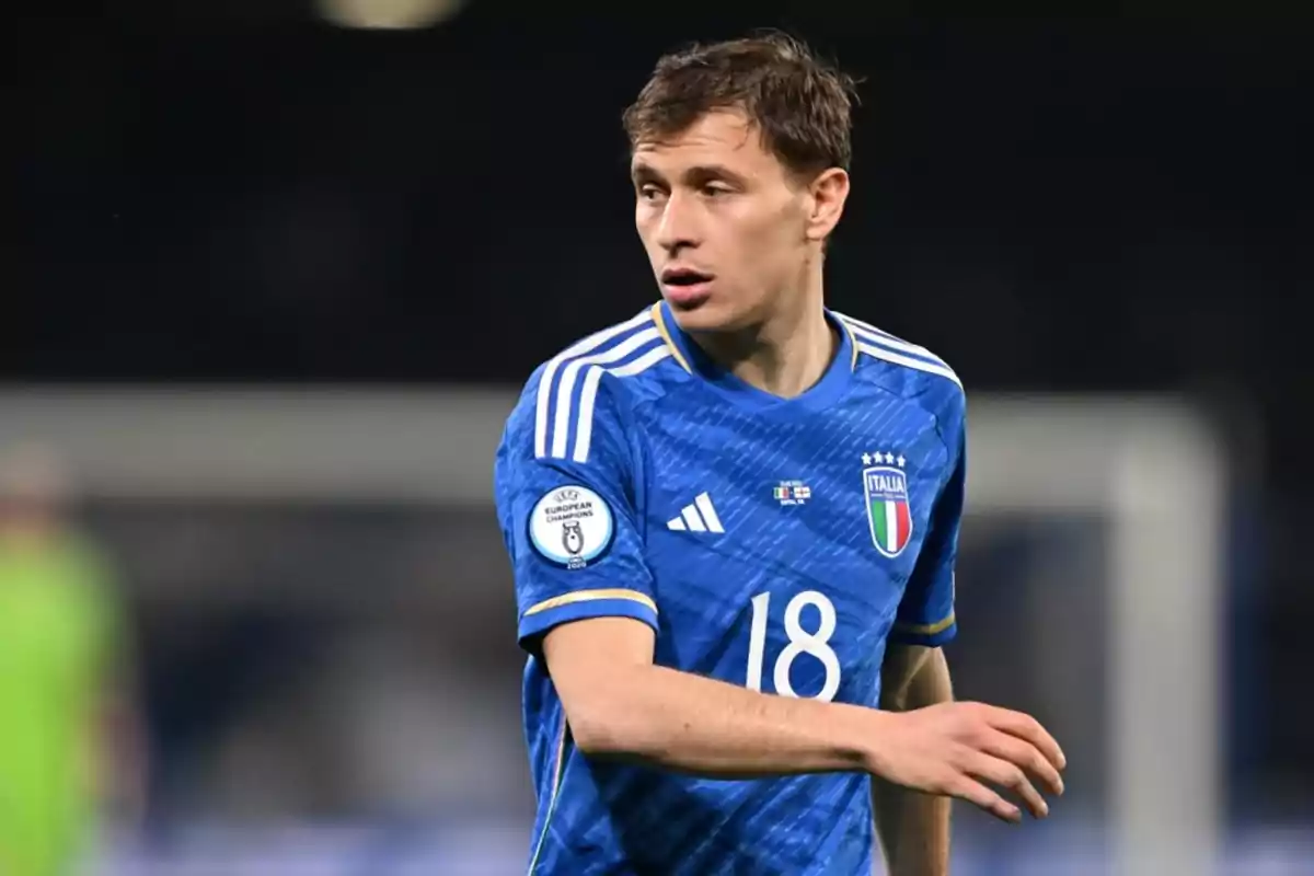 Jugador de fútbol con uniforme azul de la selección de Italia durante un partido.