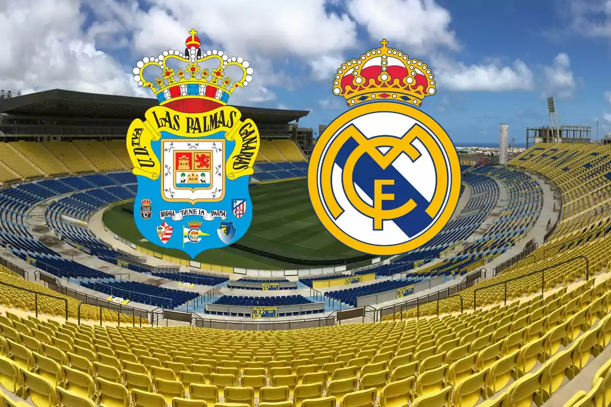 Escudos de la UD Las Palmas y el Real Madrid en un estadio de fútbol vacío con asientos amarillos y azules.