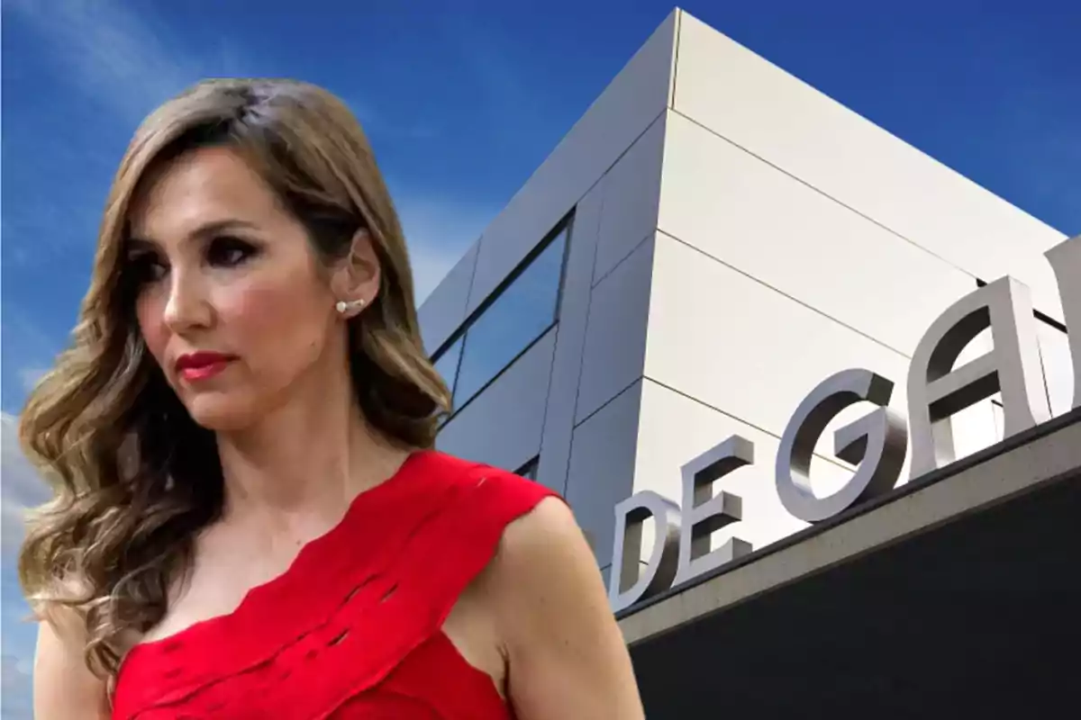 Mujer de cabello ondulado y vestido rojo frente a un edificio moderno con letras grandes en la fachada