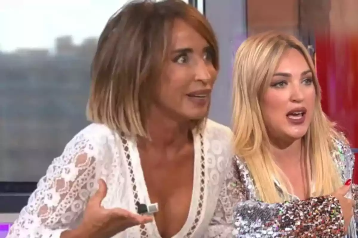 Dos mujeres conversando en un programa de televisión, una con cabello castaño y otra rubia, ambas con expresiones animadas.