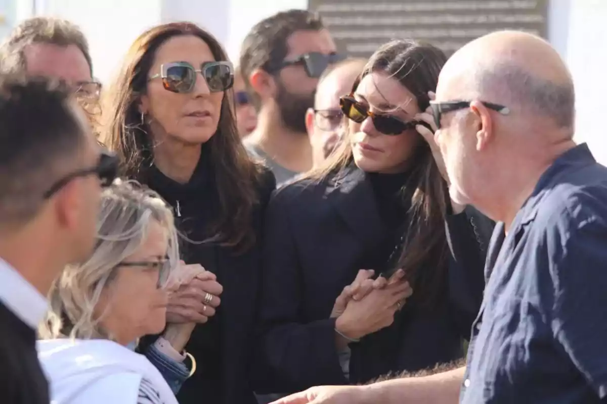 Un grupo de personas con gafas de sol conversando al aire libre.