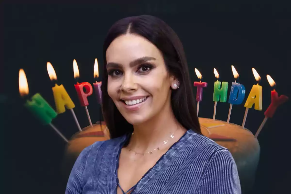 Mujer sonriendo frente a un pastel de cumpleaños con velas encendidas que forman la palabra "HAPPY BIRTHDAY"