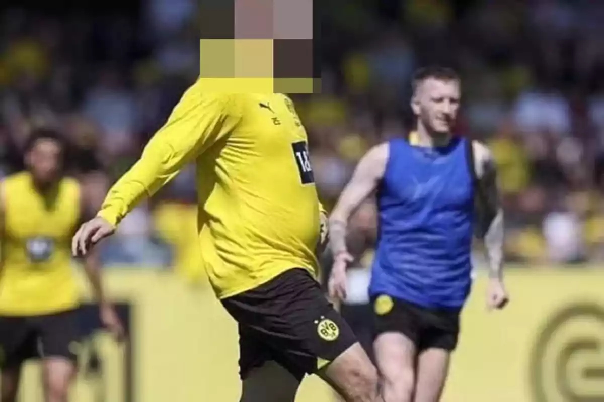 Jugadores de fútbol en el campo durante un entrenamiento, uno de ellos con la cara pixelada.