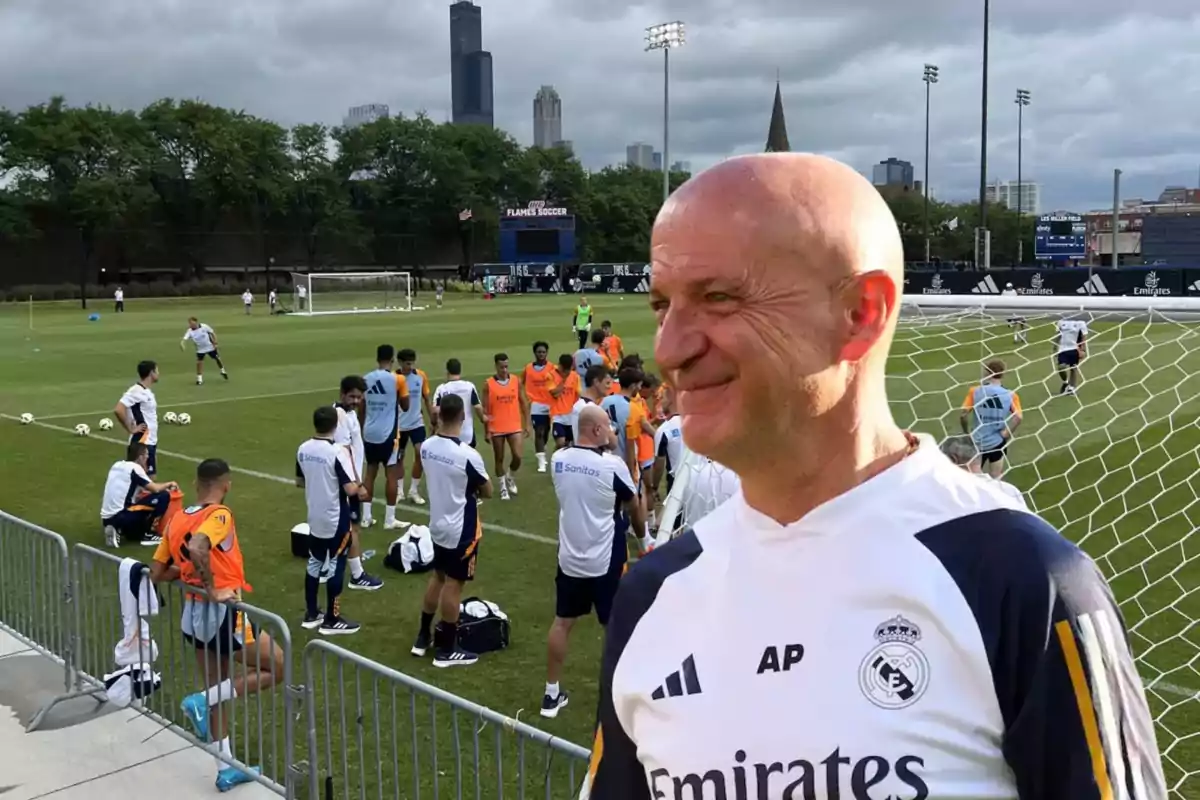 Entrenamiento del equipo de fútbol con un entrenador sonriente en primer plano.