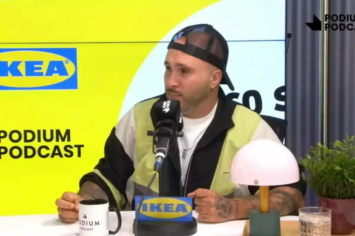 Kiko Rivera con gorra al revés participa en un podcast frente a un micrófono con logos de IKEA y Podium Podcast.