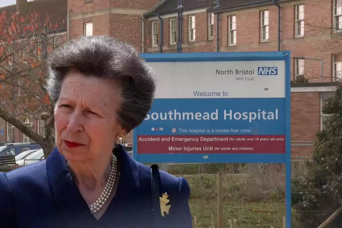 Una mujer mayor con cabello canoso y un collar de perlas está de pie frente a un cartel que dice "Welcome to Southmead Hospital" en el North Bristol NHS Trust.