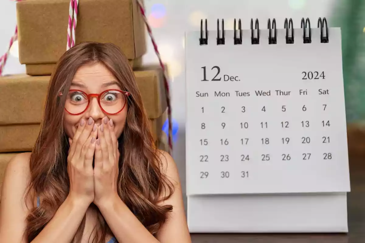 Una mujer con gafas rojas se muestra sorprendida frente a un calendario de diciembre de 2024 y varias cajas de regalo apiladas.