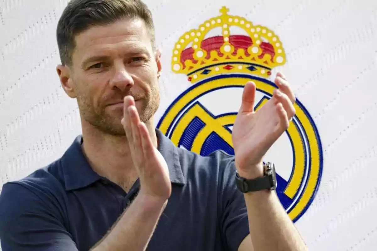 Una persona aplaudiendo frente al escudo de un equipo de fútbol.