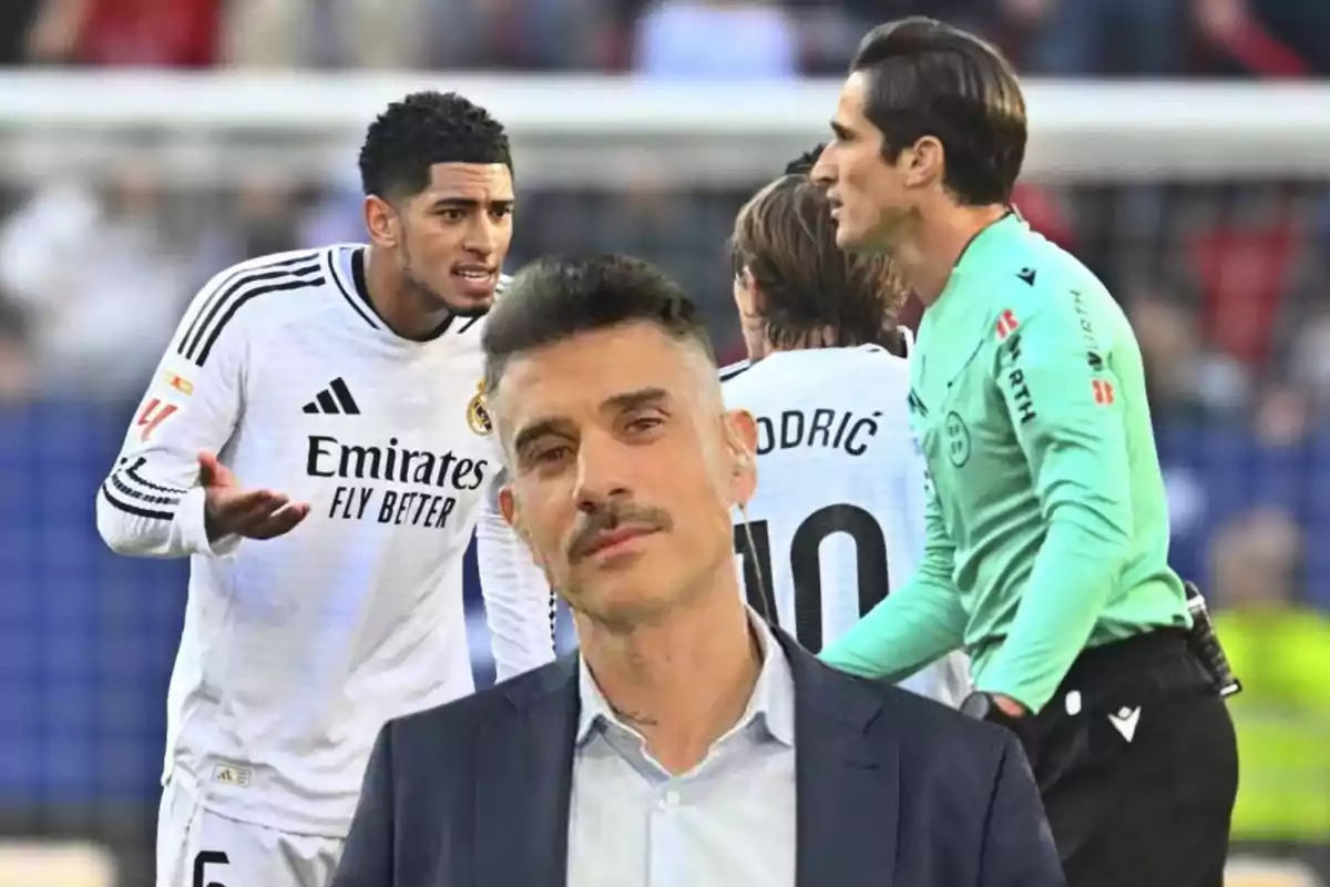 Un hombre con bigote y traje está en primer plano mientras al fondo se observa a jugadores de fútbol y un árbitro en una discusión durante un partido.