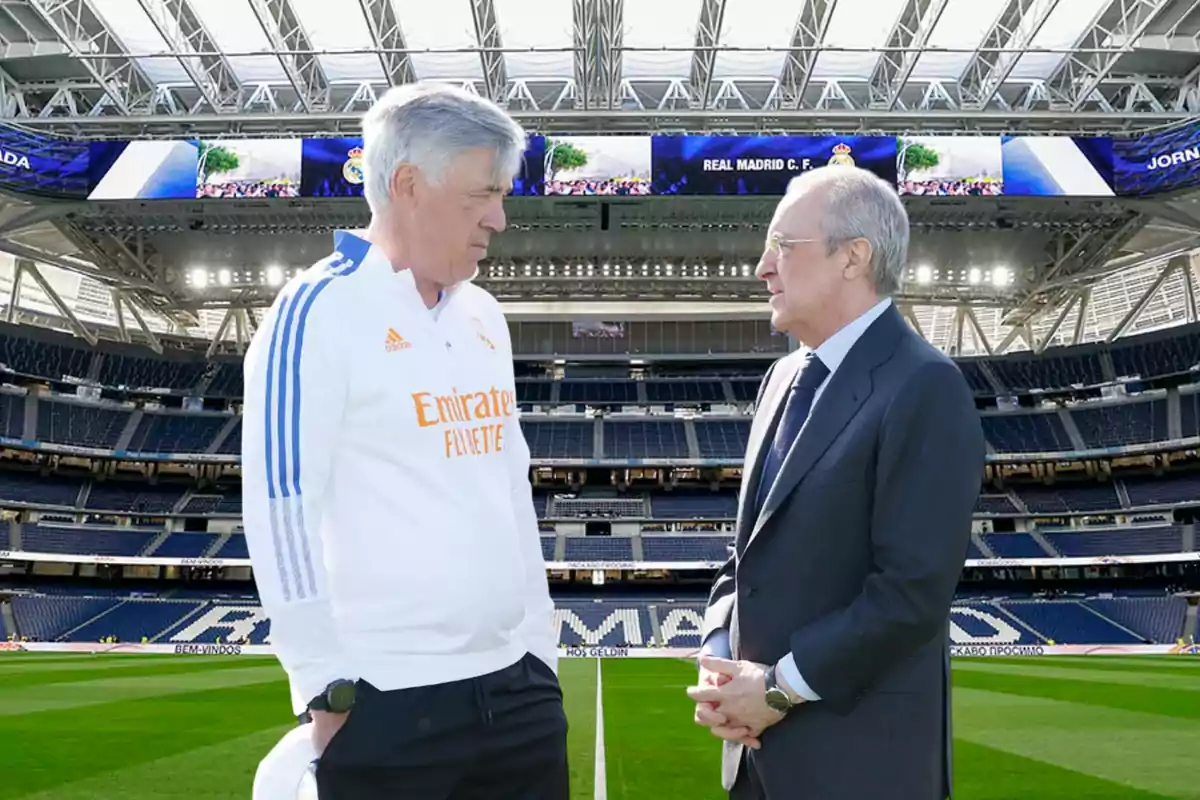 Dos hombres conversan en el centro de un estadio de fútbol moderno y vacío