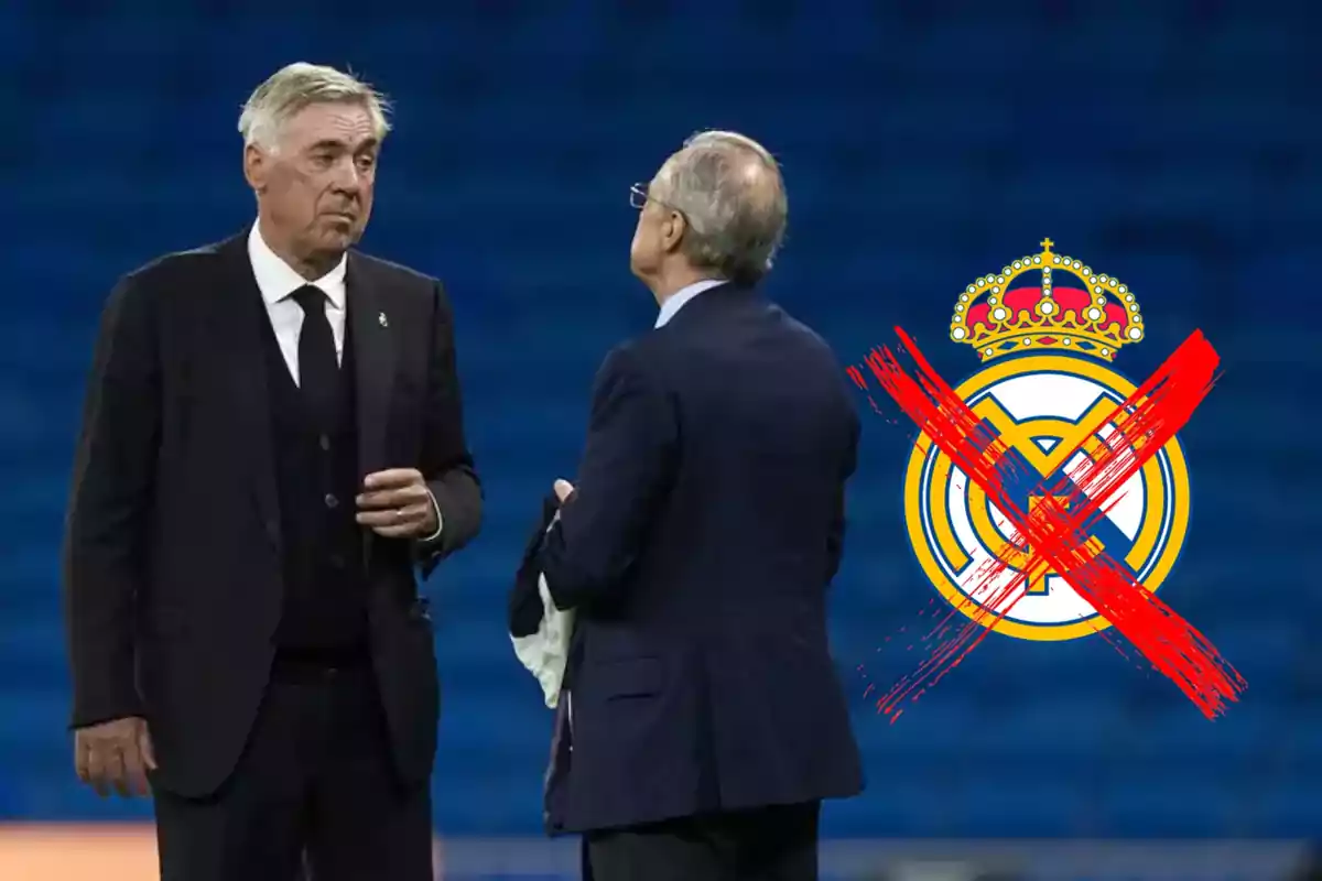 Dos hombres de traje conversan en un estadio con el logo del Real Madrid tachado en rojo al fondo.