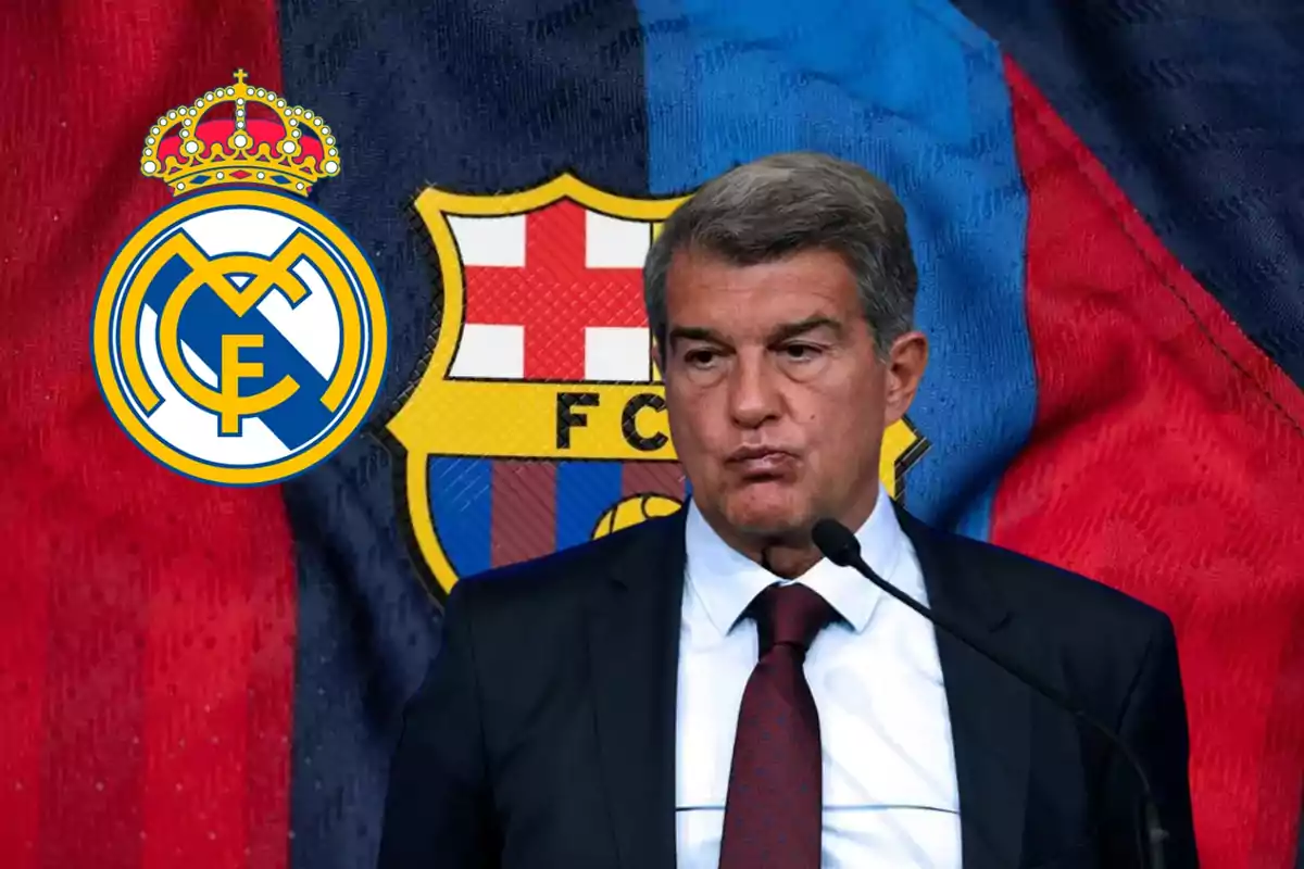 Un hombre en traje frente a un micrófono con los escudos del Real Madrid y el FC Barcelona de fondo.