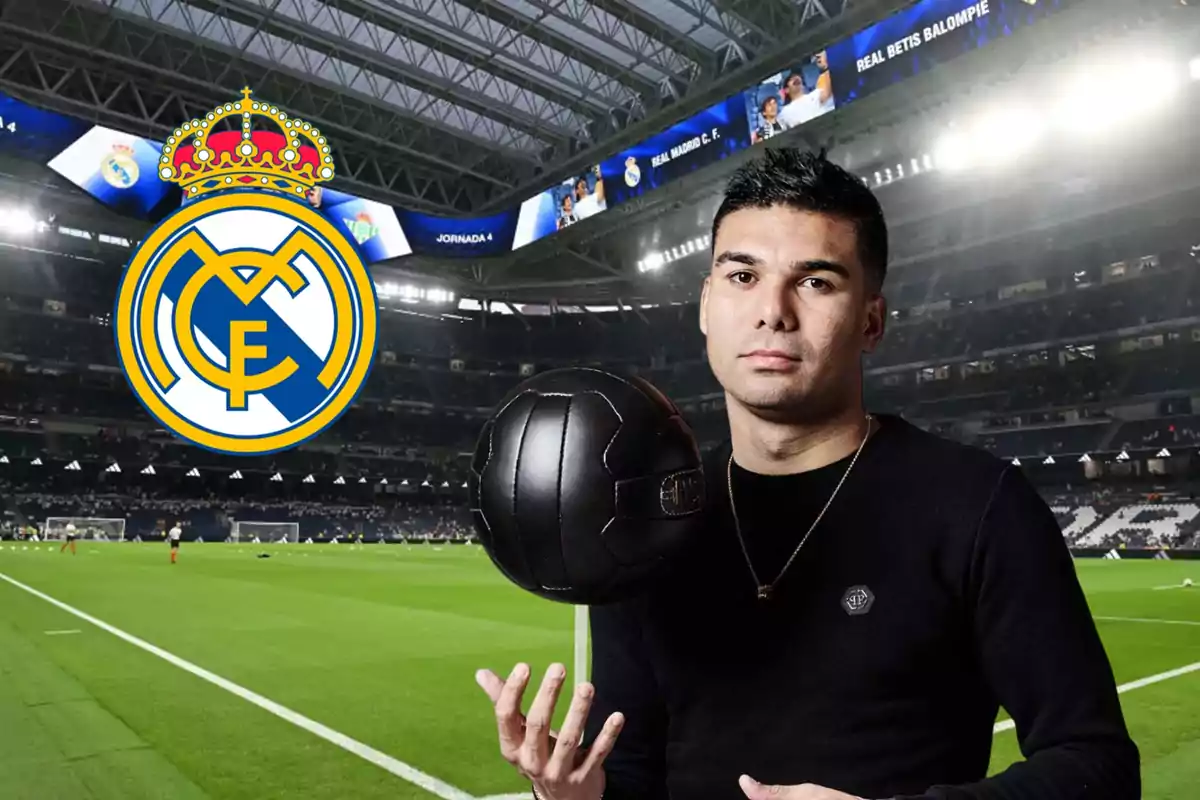 Un hombre con un balón de fútbol negro en un estadio, con el escudo del Real Madrid en el fondo.