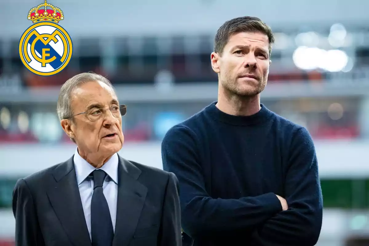 Dos hombres de pie con el escudo del Real Madrid en la esquina superior izquierda y un fondo desenfocado de estadio