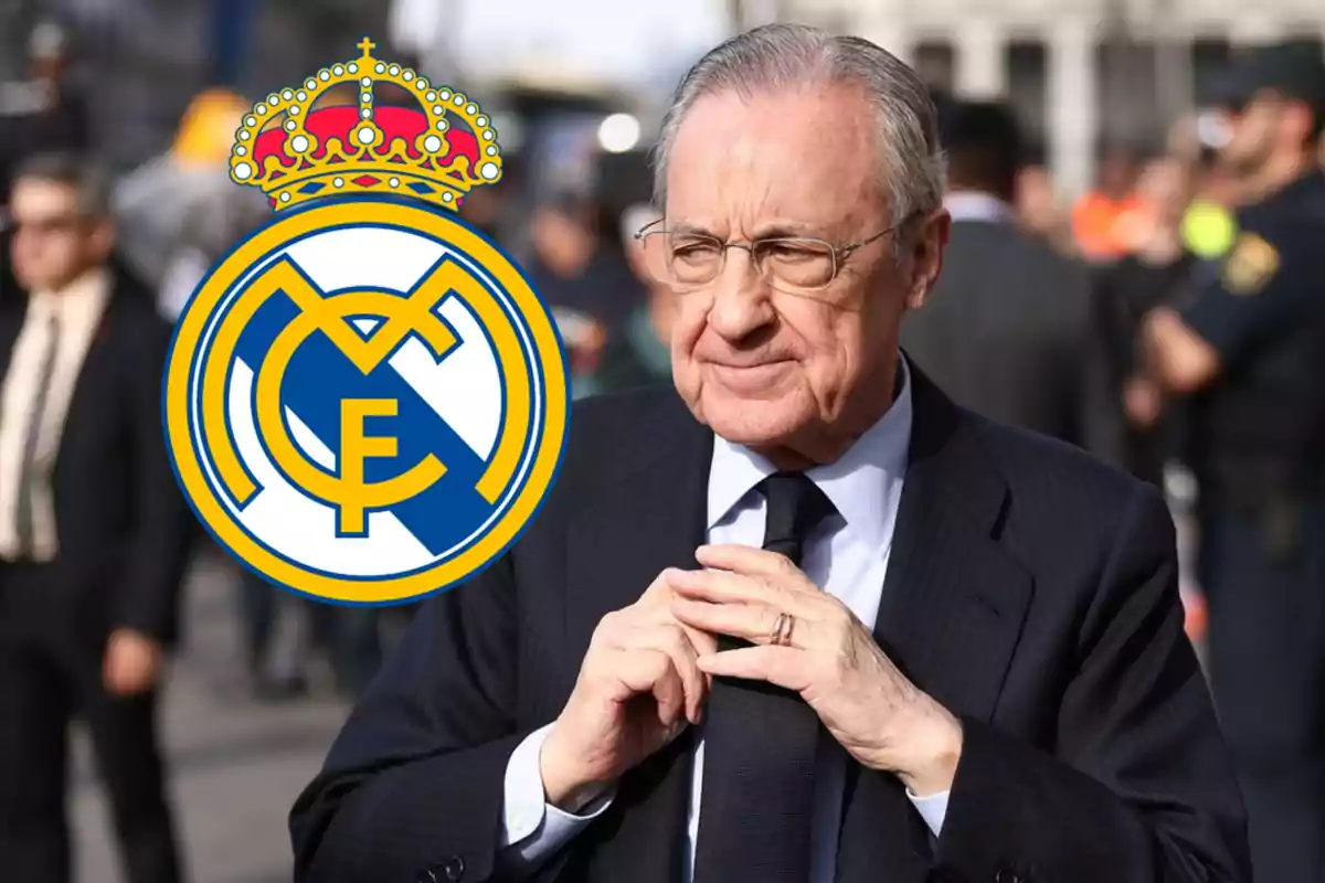 Un hombre de traje con el logo del Real Madrid a su lado.